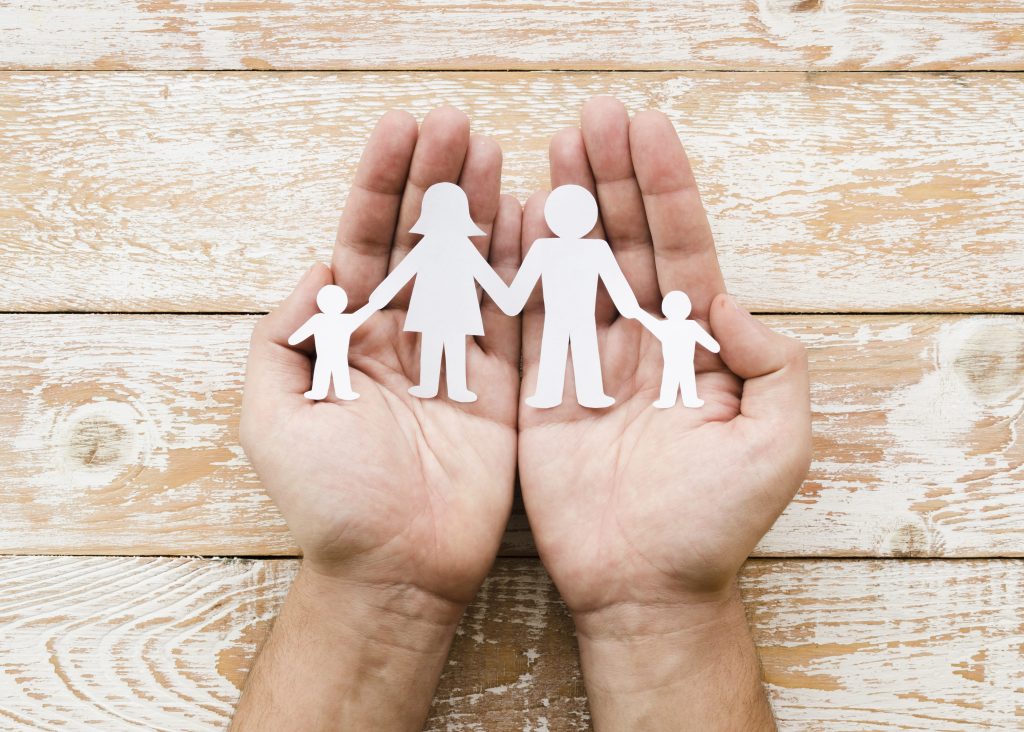 Pessoa, segurando, família papel, em, mãos representando um seguro de vida resgatável