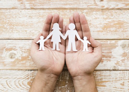 Pessoa, segurando, família papel, em, mãos representando um seguro de vida resgatável